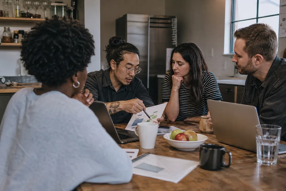 Small team discussing a weekly report in a company meeting room
